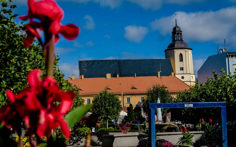 Kościół z wysoką wieżą pośród zielonych wzgórz