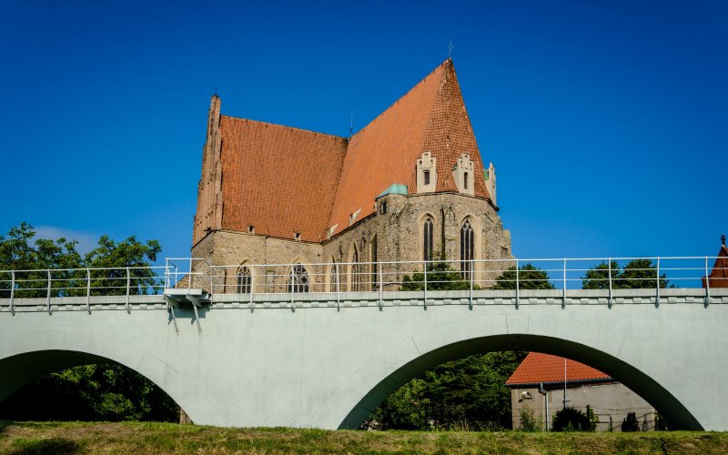 Zabytkowy kompleks budynków otoczony parkiem widziany z lotu ptaka