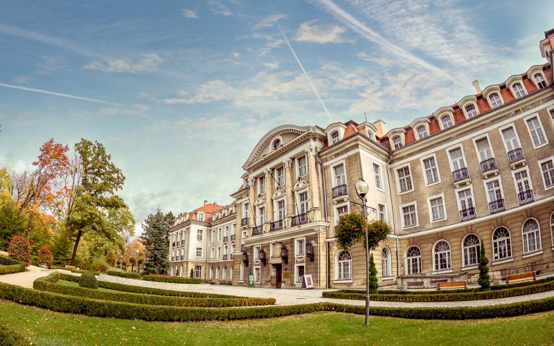 Oświetlony budynek wśród zaśnieżonych drzew zimą o zmierzchu