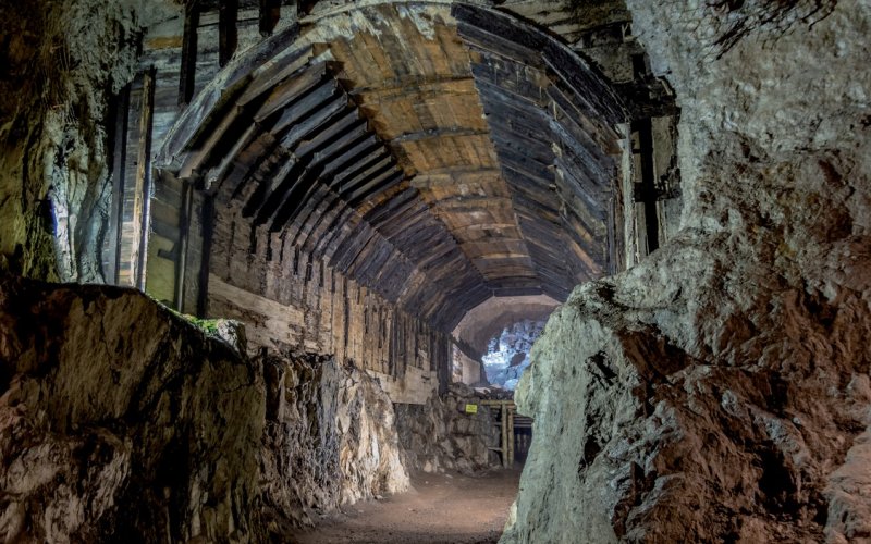 Kamienny tunel w dawnych podziemiach lub kopalni z oświetlonym przejściem
