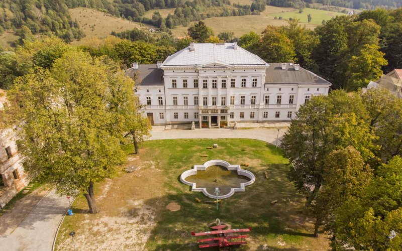 Pałac otoczony parkiem z alejkami i drzewami