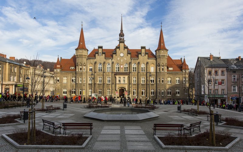 Historyczne kamienice na rynku miejskim z fontanną i brukowanym placem