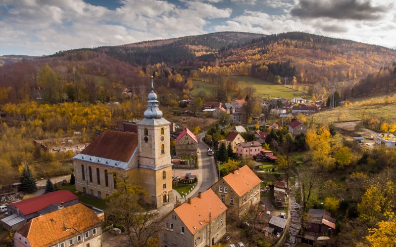 Kościół i zabudowa miasteczka wśród jesiennych wzgórz