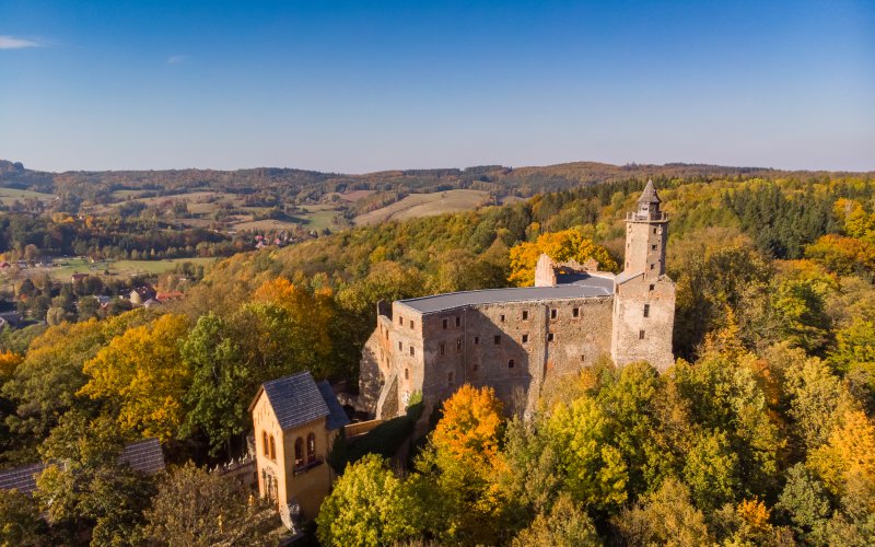 Twierdza na wzgórzu otoczona jesiennym lasem